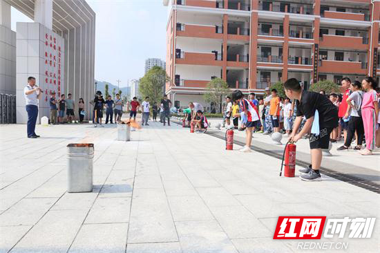 消防宣传员向新生演示灭火器使用方法.jpg