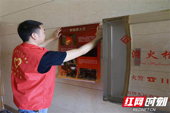 志愿者在小区内粘贴宣传挂图.jpg 志愿者在小区内粘贴宣传挂图.jpg