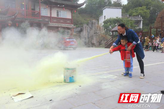 老师带领学生进行灭火器实操.jpg 老师带领学生进行灭火器实操.jpg